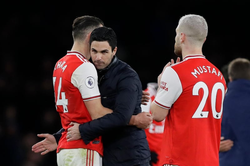 Arsenal manager Mikel Arteta congratulates Granit Xhaka, left, and Shkodran Mustafi. AP