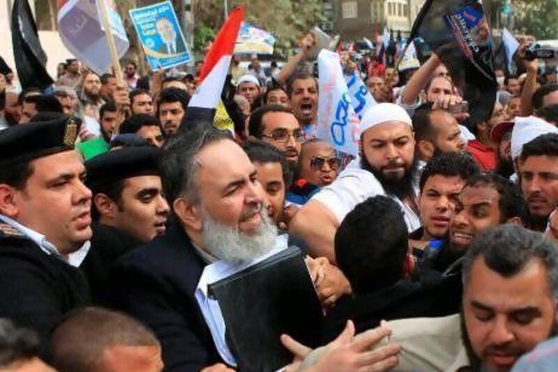 The Egyptian Salafist presidential candidate Hazem Abu Ismail is surrounded by security guards and hundreds of his supporters during a rally yesterday outside a Cairo courtroom.