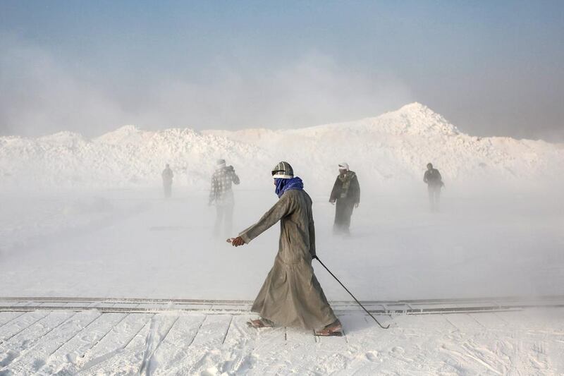 Limestone quarry workers walk through a cloud of dust spewed into the air by rotor blades of the stone-cutting machinery in the desert of Minya, southern Egypt. Mosa'ab Elshamy / AP Photo