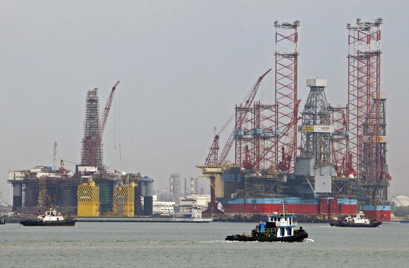 Tugboats pass jack-up rigs at a Keppel shipyard in Singapore. Edgar Su / Reuters