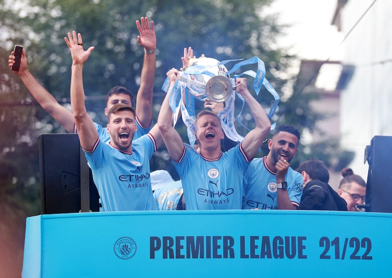 Manchester City's Oleksandr Zinchenko, Riyad Mahrez and Ruben Dias celebrate with the Premier League trophy during the victory parade on Monday, May 23. Reuters