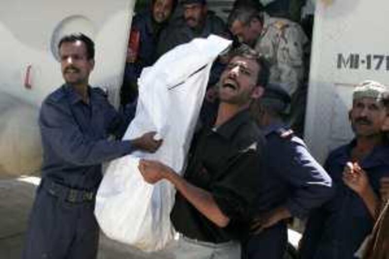 A Yemeni soldier and a health worker carry one of three retrieved bodies of slain kidnapped foreigners off a military helicopter in San'a, Yemen Tuesday, June 16, 2009. Shepherds found the mutilated bodies on Monday of two German nurses and a South Korean teacher who were kidnapped while picnicking in an area of Yemen known as a hideout for al-Qaida. Mohammed al-Qadhi/The National