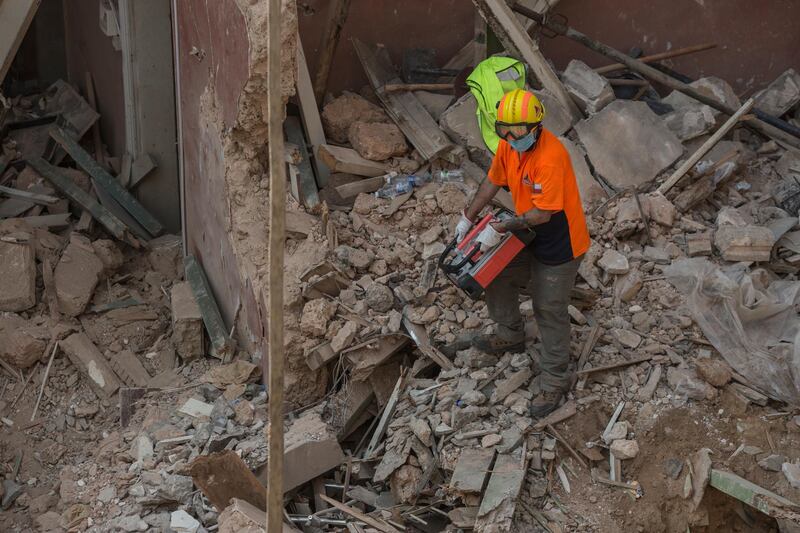 A Chilean rescue worker uses a sensitive listening device to locate vital signs of a survivor at a site of the Beirut blast in Beirut, Lebanon. A sniffer dog with a Chilean rescue crew responded to the presence of a person in the rubble of a building damaged in the deadly explosion on August 4. The condition of the person is unknown. Getty Images