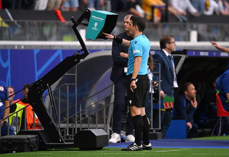 Referee Umut Meler looks at the pitchside monitor before deciding to disallow Romelu Lukaku's late goal for Belgium. Getty Images