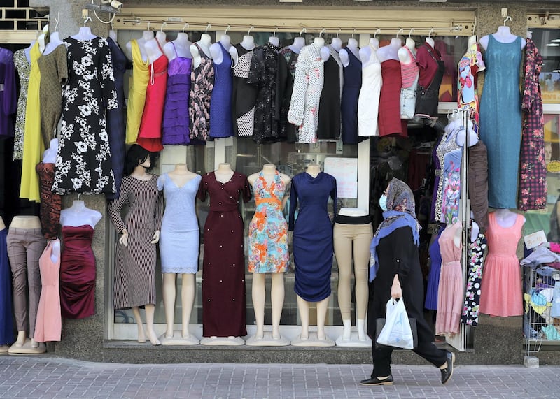 Dubai, United Arab Emirates - Reporter: N/A: Coronavirus / Covid-19. A women with her shopping walks passed a dress shop in Al Hudaiba Road, Satwa after the lifting of the 24hr lockdown. Saturday, April 25th, 2020. Dubai. Chris Whiteoak / The National
