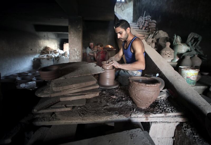 An Egyptian worker shapes a clay ornament at one of the traditional pottery workshops, in Old Cairo, Egypt.