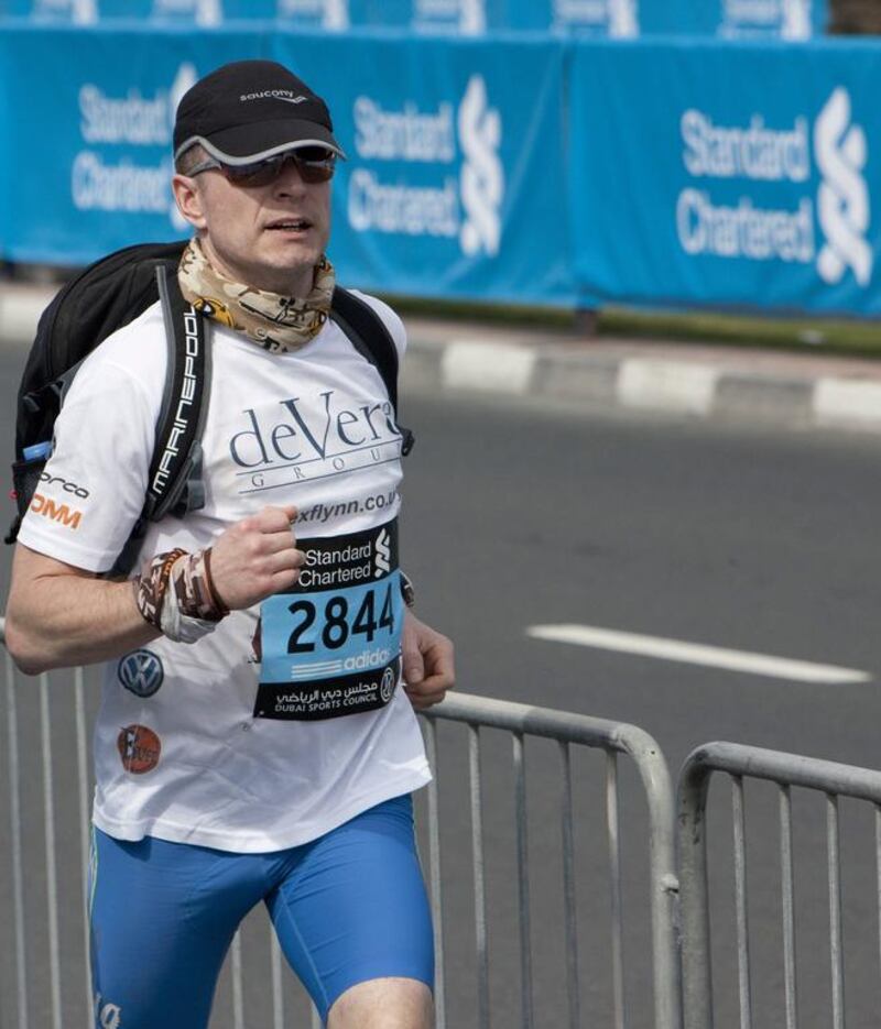 Parkinson's sufferer Alex Flynn finishes his 10 million metres challenge during the Dubai Marathon on Friday. The milestone is the equivalent of running 237 marathons. Antonie Robertson / The National 