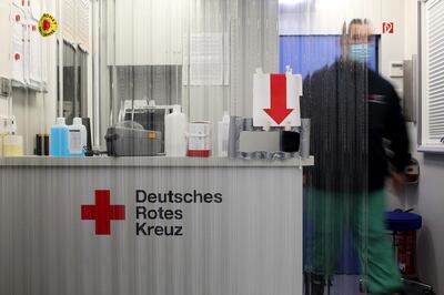 The German Red Cross symbol sits on a reception desk at a Covid-19 test center for coach passengers arriving in Berlin, Germany, on Monday, Oct. 12, 2020. Chancellor Angela Merkel said Germany is at a tipping point in Europe’s resurgent virus pandemic and France reported the most daily cases yet, signaling the potential for rising economic and human costs heading into the winter. Photographer: Liesa Johannssen-Koppitz/Bloomberg