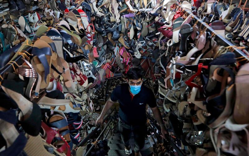 A mask-clad owner climbs the stairs of his shoe store in Erbil, northern Iraq. AFP