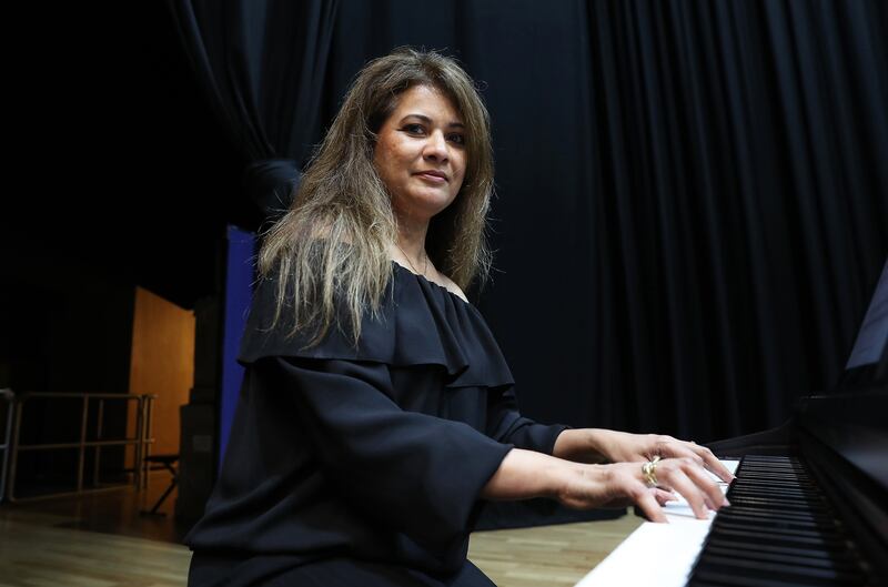 Nerissa Lobo playing the piano as the musicians tune up.