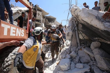 Members of the White Helmets pull out an injured child from under the rubble in Syria's northwestern Idlib province on July 22, 2019. AFP