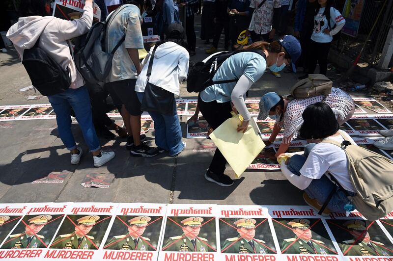 Posters featuring military chief Gen Min Aung Hlaing are placed on the road during a demonstration against the military coup, in Yangon, Myanmar. AFP