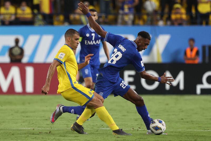 Al Hilal midfielder Mohamed Kanno is marked by Nassr's forward Abderrazak Hamdallah. AFP