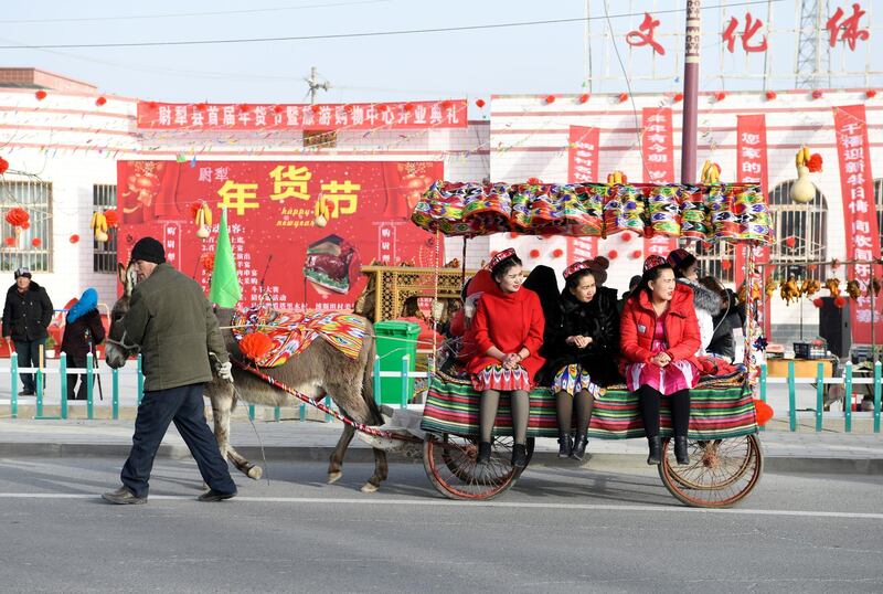 Passengers ride a donkey cart in Lopnur county, Xinjiang Uighur Autonomous Region, China. Reuters