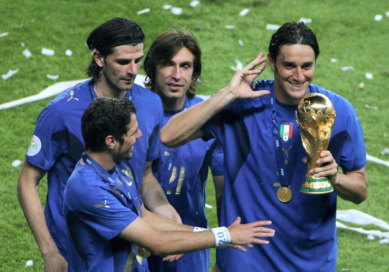 (From L) Italian midfielder Simone Perrotta, Italian forward Vincenzo Iaquinta, Italian midfielder Andrea Pirlo, and Italian forward Luca Toni celebrate with the trophy after the World Cup 2006 final football game France vs Italy, 09 July 2006 in Berlin at the Olympic Stadium.  Italy won the 2006 football World Cup by defeating France on penalties. AFP PHOTO  DANIEL GARCIA (Photo by DANIEL GARCIA / AFP)