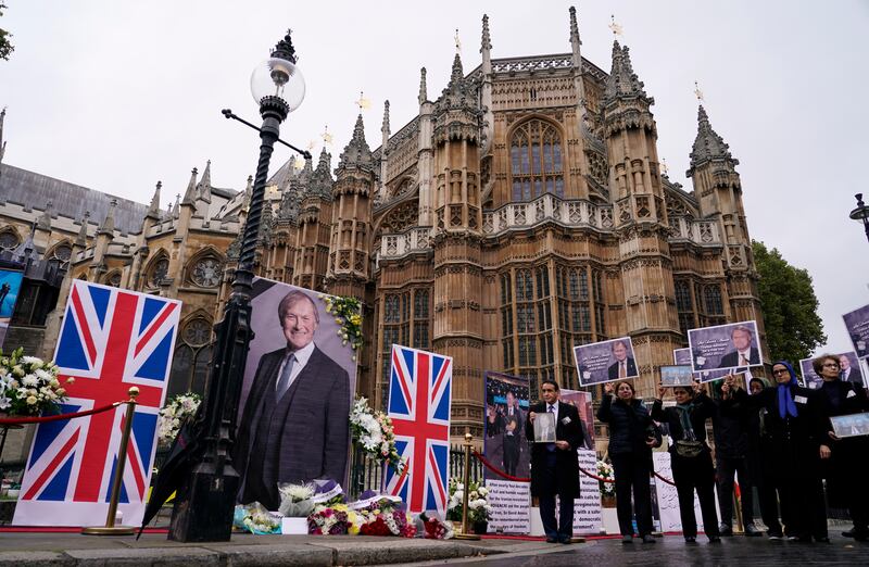 Supporters of the National Council of Resistance of Iran hold a memorial service for British MP David Amess outside the Houses of Parliament in London. Photo: AP