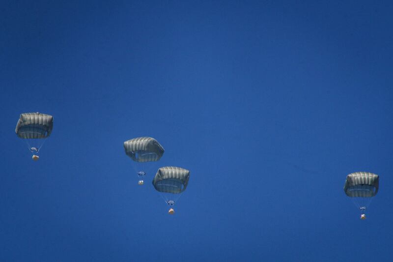 Parachutes carrying relief for Palestinians drop from an Egyptian Air Force cargo plane over central Gaza. Bloomberg