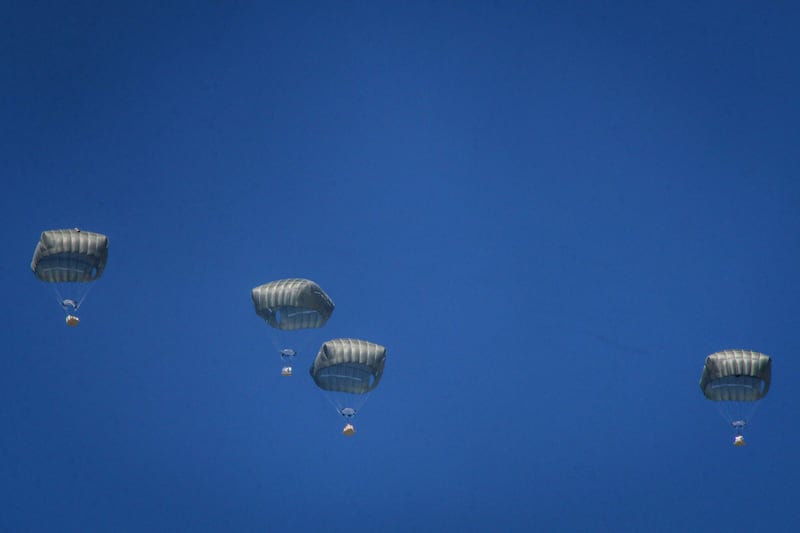 Parachutes carrying relief for Palestinians drop from an Egyptian Air Force cargo plane over central Gaza. Bloomberg
