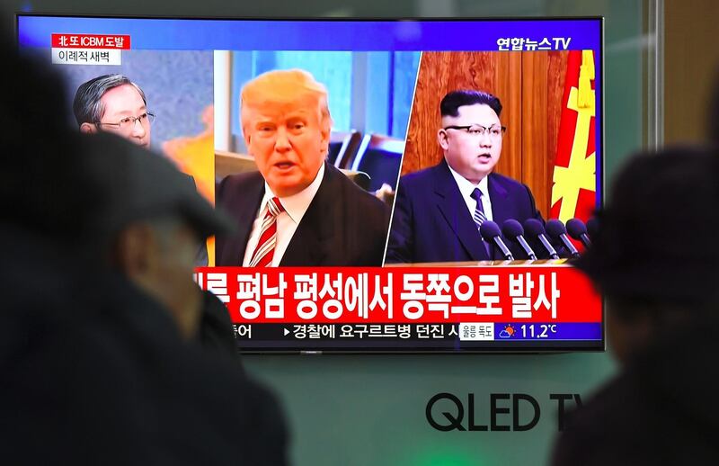 TOPSHOT - People watch a television news screen showing pictures of US President Donald Trump (C) and North Korean leader Kim Jong-Un (R) at a railway station in Seoul on November 29, 2017.
North Korea test fired what appeared to be an intercontinental ballistic missile on November 29, in a major challenge to US President Donald Trump after he slapped fresh sanctions on Pyongyang and declared it a state sponsor of terrorism. / AFP PHOTO / JUNG Yeon-Je