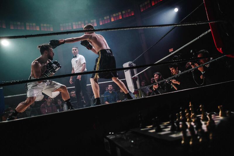 TOPSHOT - Athletes compete in a chessboxing match organised at the Cabaret Sauvage, in Paris on Saturday, November 9. The contest alternates between a round of chess and a round of boxing in three minute intervals. AFP