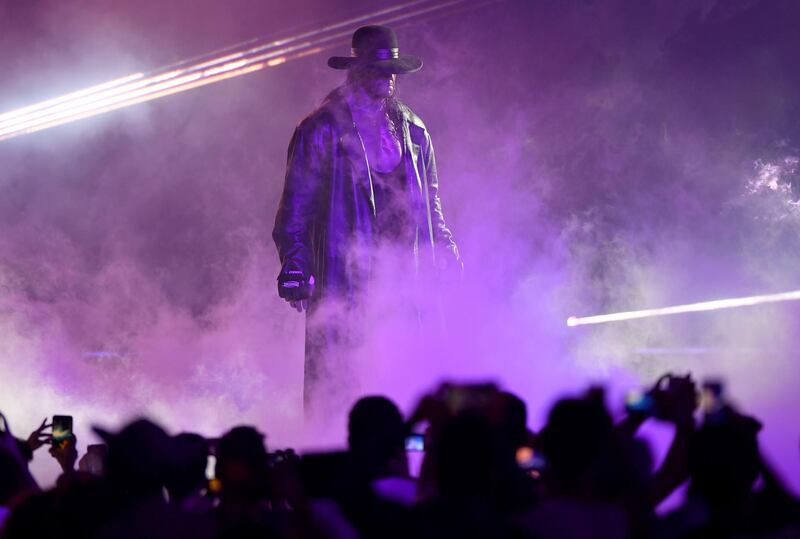 TOPSHOT - World Wrestling Entertainment star The Undertaker makes his way to the ring during a match at the World Wrestling Entertainment (WWE) Super Showdown event in the Saudi Red Sea port city of Jeddah late on January 7, 2019.
  / AFP / Amer HILABI
