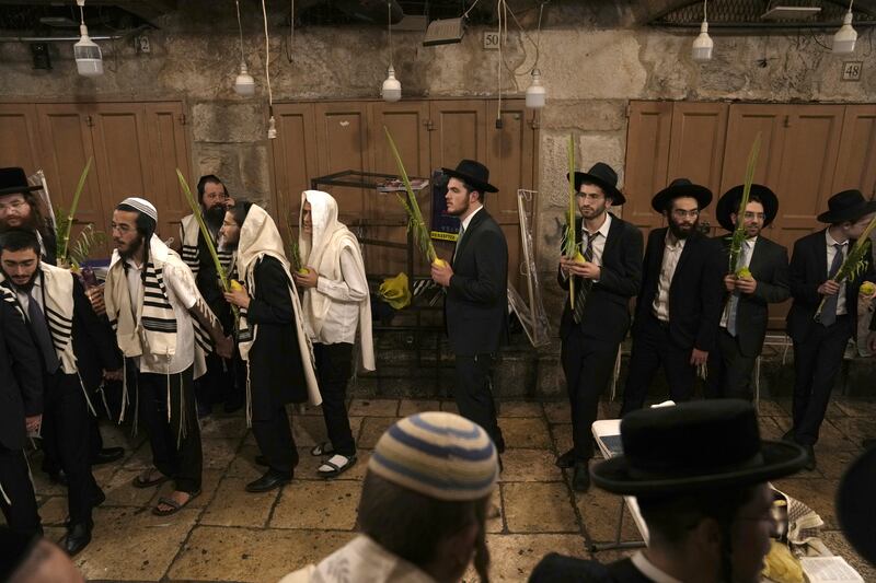 Ultra-Orthodox Jews pray during the week-long Jewish holiday of Sukkot, next to one of the gates to Al Aqsa Mosque compound. AP