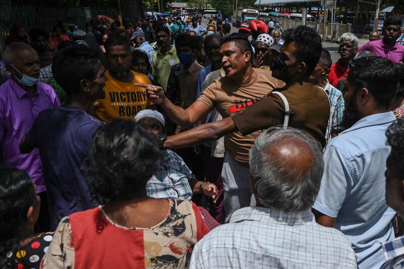 Sri Lankans quarrel as they wait for gas at a distribution point. AFP