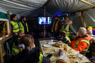 Protesters watch TV in a tent in Montabon, near Le Mans, in December 2018 as French President Emmanuel Macron delivers a speech. AFP