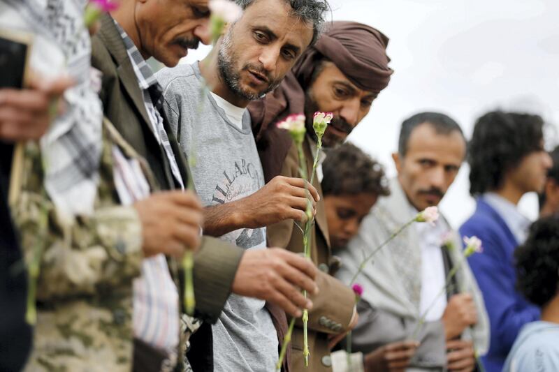 Members of the Baha'i faith hold flowers as they demonstrate outside a state security court during a hearing in the case of a fellow Baha'i man charged with seeking to establish a base for the community in Yemen, in the country's capital Sanaa April 3, 2016. REUTERS/Khaled Abdullah - GF10000369865