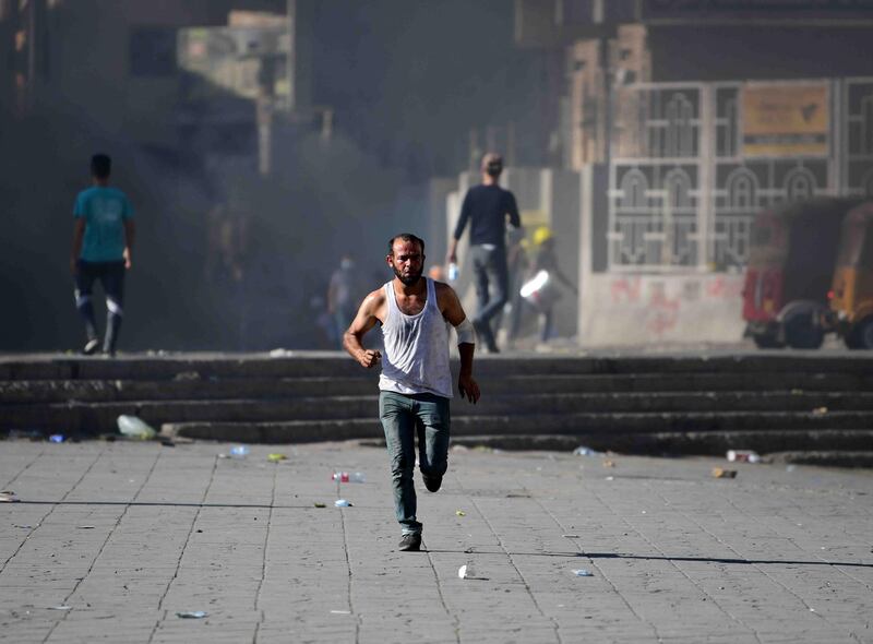 A protester runs to safety during clashes between protesters and riot police forces in Al Rasheed street, near the Al Tahrir square in Baghdad.  EPA