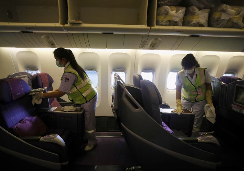 Staff cleaning business class seats on a Thai Airways aircraft. EPA