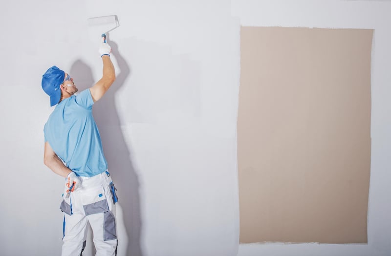 Room Painter at Work. Covering Darker Paint by Fresh and Lighter One. Apartment Renovation. Refreshing the Walls. Construction Theme. Getty Images