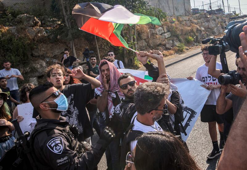 Israeli police confiscate a flag from a protester during a demonstration by Palestinian, Israeli and foreign activists against Israeli occupation and settlement activity, in Sheikh Jarrah in East Jerusalem on July 30, 2021. AFP
