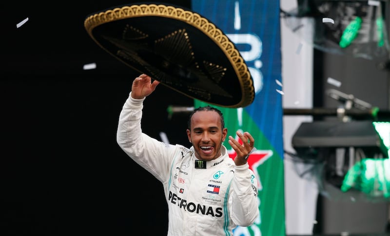 Mercedes driver Lewis Hamilton, of Britain, throws a Mexican Charro hat to the crowd as he celebrates his victory in the Formula One Mexico Grand Prix auto race at the Hermanos Rodriguez racetrack in Mexico City, Sunday, Oct. 27, 2019. (AP Photo/Rebecca Blackwell)
