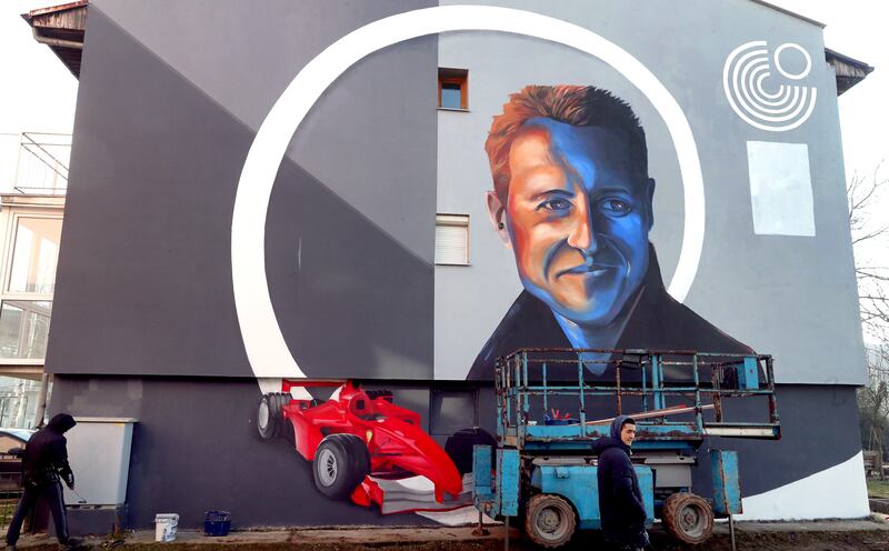 Bosnian artists work on a mural depicting former seven-time Formula One champion Michael Schumacher in Dobrinja, a suburb of Sarajevo, Bosnia and Herzegovina, 04 January 2022.  The artwork is painted on a side of a building that was partially rebuilt by donations raised by Schumacher after the war in Bosnia.   EPA / FEHIM DEMIR