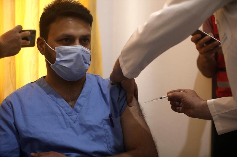 A Syrian nurse receives AstraZeneca COVID-19 vaccine, at Ibn Sina Hospital, in Idlib town, northwestern Syria, Saturday, May 1, 2021. The inoculation campaign against COVID-19 kicked off in Syria's last rebel-held enclave in the country's northwest. (AP Photo/Ghaith Alsayed)