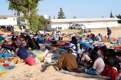 FILE PHOTO: Migrants are seen with their belongings in the yard of a detention centre for mainly African migrants, hit by an air strike, in the Tajoura suburb of Tripoli, Libya July 3, 2019. REUTERS/Ismail Zitouny/File Photo/File Photo