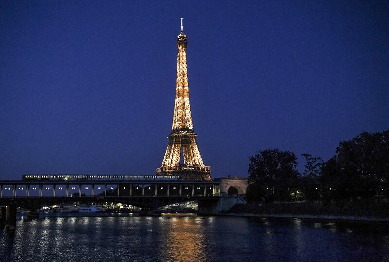 This photograph taken late April 25, 2020, shows a metro train passing along The Bir-Hakeim Bridge across The River Seine in front of The Eiffel Tower in Paris, on the 40th day of a lockdown in France aimed at curbing the spread of the COVID-19 pandemic, caused by the novel coronavirus. (Photo by ALAIN JOCARD / AFP)