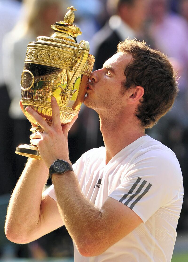 Britain's Andy Murray kisses the winner's trophy after beating Serbia's Novak Djokovic in the men's singles final on day thirteen of the 2013 Wimbledon Championships tennis tournament at the All England Club in Wimbledon, southwest London, on July 7, 2013. Murray won 6-4, 7-5, 6-4. AFP PHOTO / GLYN KIRK  - RESTRICTED TO EDITORIAL USE (Photo by GLYN KIRK / AFP)