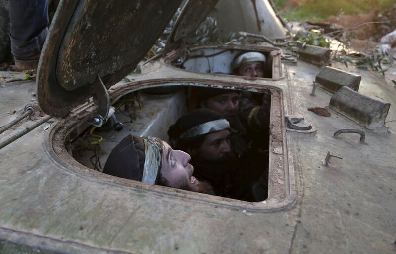 Rebel fighters sit inside an armoured vehicle during what they said was an offensive to take the Syrian city of Idlib on March 24, 2015. Khalil Ashawi / Reuters 