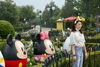 epa08413838 A tourist poses for photos in the Disneyland theme park in Shanghai, China, 11 May 2020, the first opening day after the prolonged closure due to the coronavirus pandemic.  EPA/HU MIN CHINA OUT