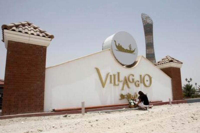 A woman places flowers at Villaggio Mall in Doha May 29, 2012. At least 19 foreign nationals, including 13 children, were killed in a fire that ripped through the upscale shopping mall in Qatar on Monday, the country's interior ministry said.   REUTERS/Fadi Al-Assaad  (QATAR - Tags: DISASTER) *** Local Caption ***  QAT04_QATAR-FIRE-_0529_11.JPG