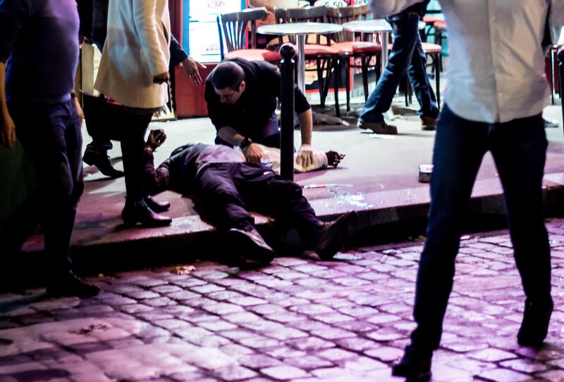 A man lies on the pavement near the cafe "A la Bonne Biere" in Paris, on November 13, 2015, following a series of coordinated attacks in and around Paris which left more than 120 people dead.   AFP PHOTO / ANTHONY DORFMANN / AFP PHOTO / Anthony DORFMANN