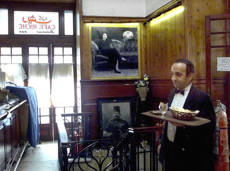 A waiter walks in front of a picture of Egyptian singer Umm Kulthum at the historical Cafe Riche in Cairo in 2021. AFP