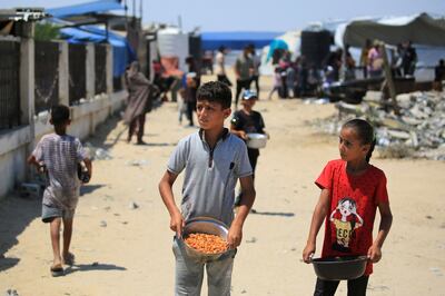 Displaced children receive food in Khan Younis. AFP