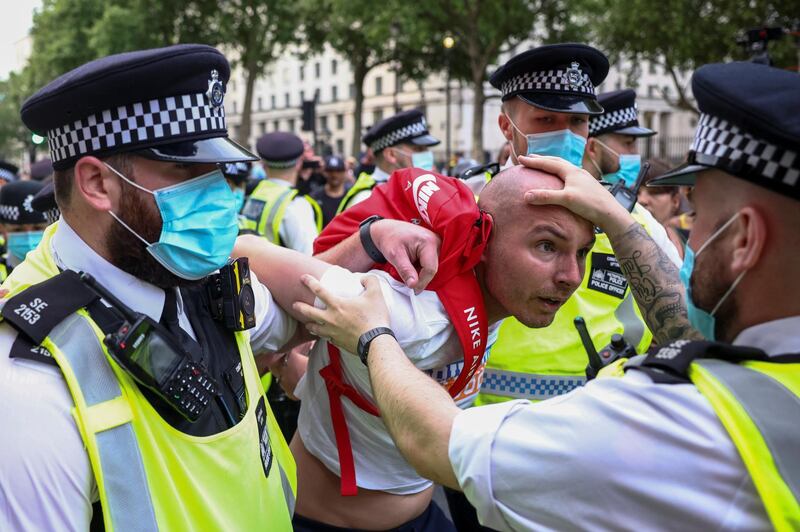 Police officers arrest a demonstrator during an anti-lockdown and anti-vaccine protest in London on June 7. Reuters
