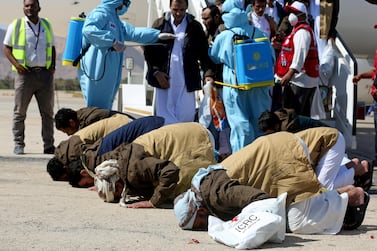 Prisoners from the Saudi-led coalition pray as they arrive following their release in a prisoner swap, at Sayoun airport, Yemen October 2020. REUTERS
