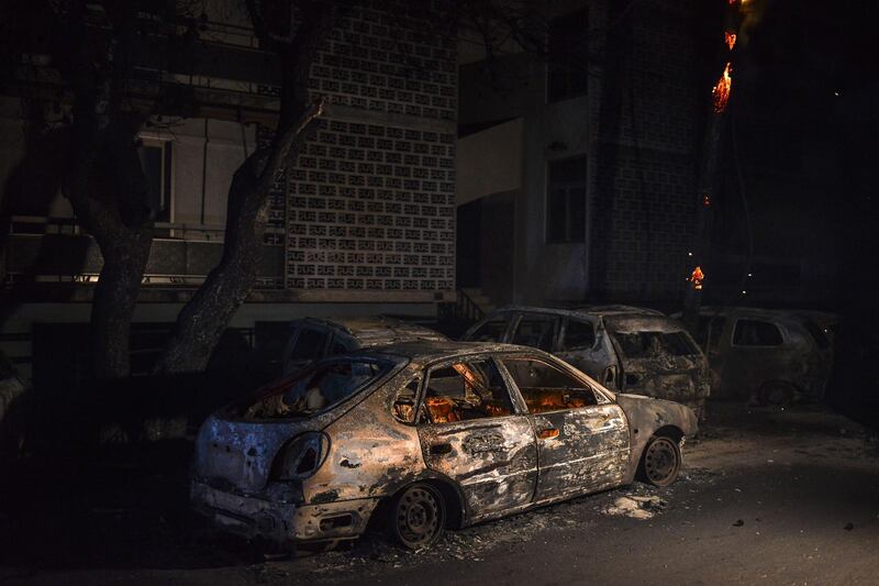 Cars are seen burned as a wildfire rages at the village of Mati, near Athens. AFP