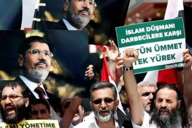 Protestors hold pictures of the ousted Egyptian president Mohammed Morsi at a rally in Istanbul on Saturday. Sedat Suna / EPA