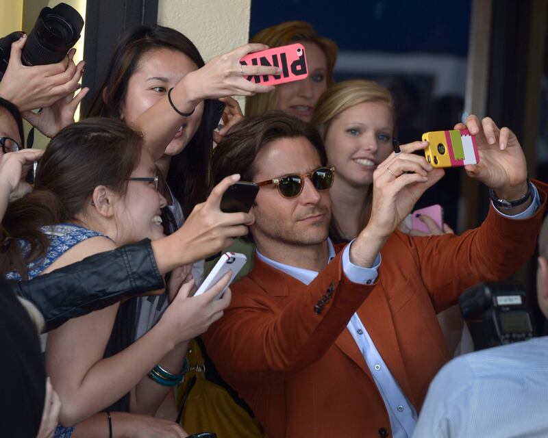 epa03709504 US actor and cast member Bradley Cooper poses with fans upon his arrival for the premiere of 'The Hangover Part III' at the Westwood Village Theatre in Los Angeles, California, USA, 20 May 2013.  EPA/PAUL BUCK *** Local Caption ***  03709504.jpg